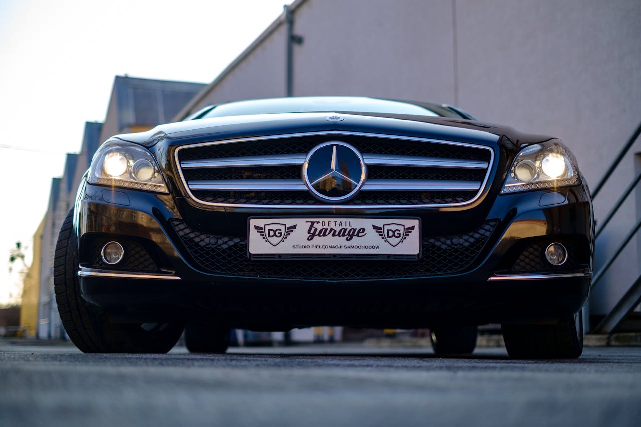 Elegant Mercedes Benz with illuminated headlights captured outdoors, showcasing style and luxury.